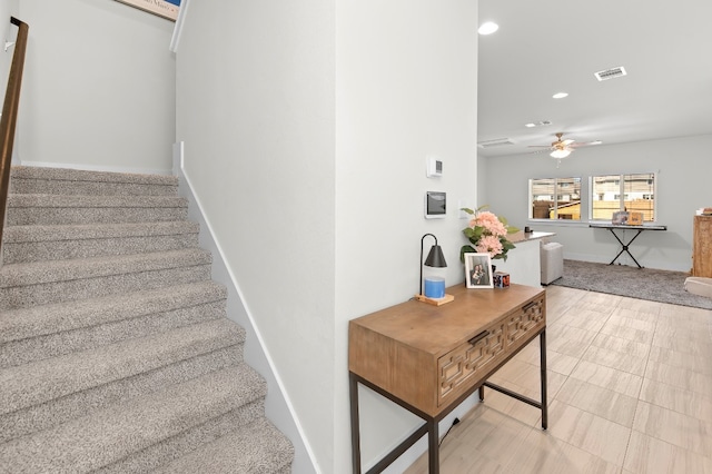 stairway featuring ceiling fan