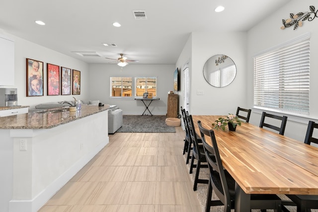 dining room featuring ceiling fan, light tile patterned floors, and sink