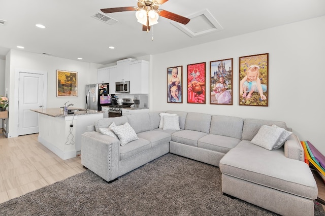 living room featuring ceiling fan and sink