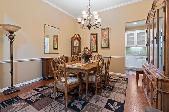 dining room featuring a notable chandelier, crown molding, and dark hardwood / wood-style flooring