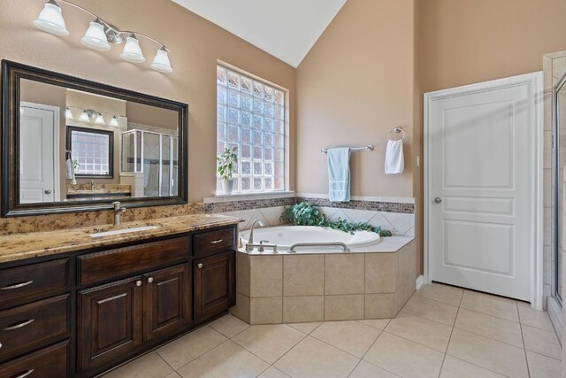 bathroom with shower with separate bathtub, lofted ceiling, vanity, and tile patterned floors