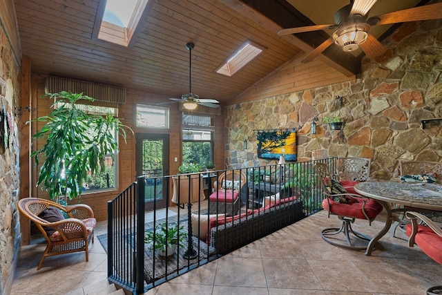 sunroom / solarium with ceiling fan, wood ceiling, and lofted ceiling with skylight