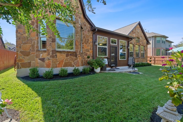 rear view of house with a patio and a yard