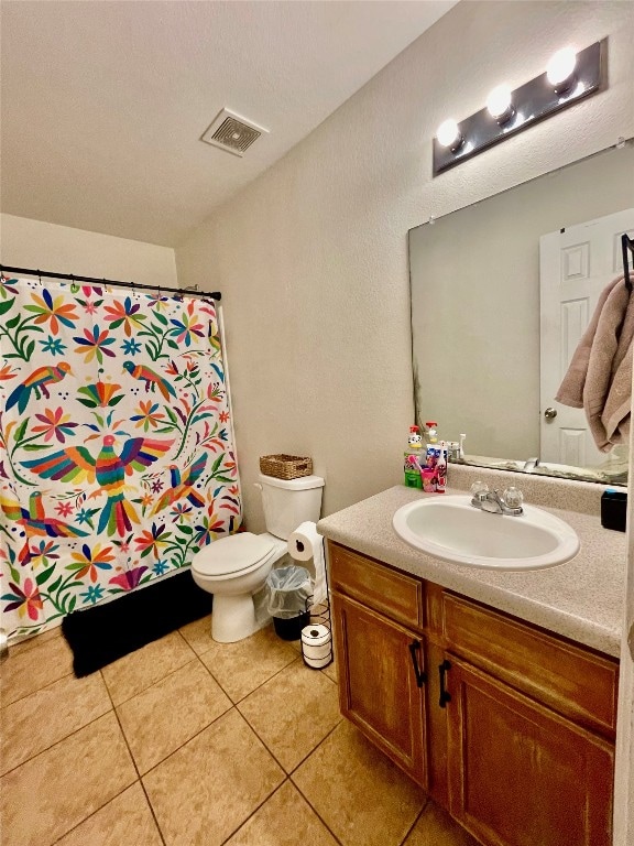 bathroom featuring tile patterned floors, walk in shower, vanity, and toilet