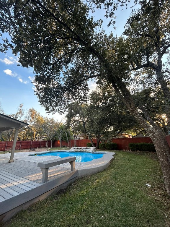 view of swimming pool featuring a deck and a yard