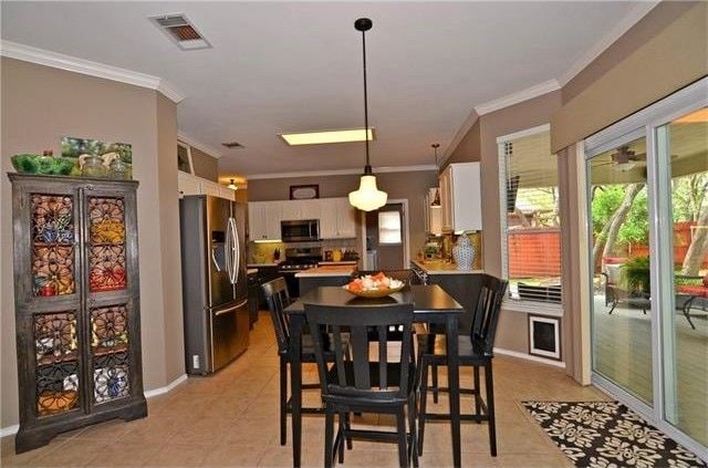 tiled dining area featuring crown molding