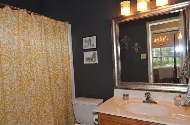 bathroom featuring vanity, toilet, and a notable chandelier