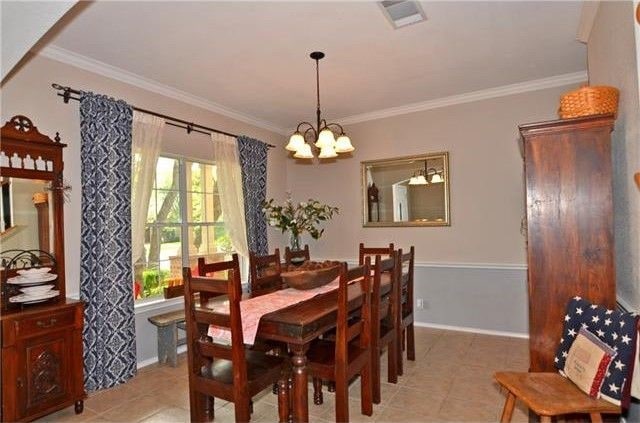 dining room featuring crown molding and a chandelier