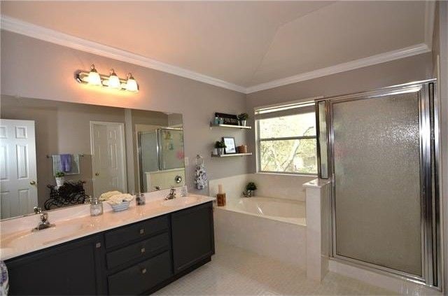 bathroom with ornamental molding, shower with separate bathtub, and vanity