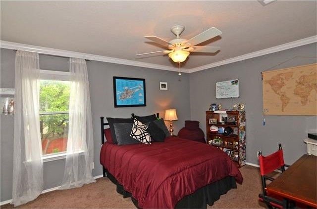 carpeted bedroom with crown molding and ceiling fan