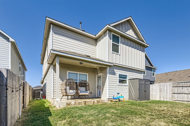 back of property with a patio area, a fenced backyard, board and batten siding, and a yard