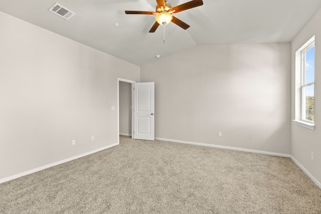 carpeted spare room featuring ceiling fan and vaulted ceiling