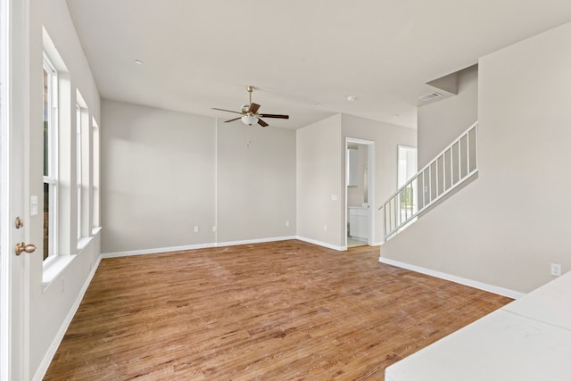 spare room featuring ceiling fan, hardwood / wood-style floors, and a healthy amount of sunlight