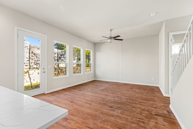 unfurnished living room with ceiling fan, a wealth of natural light, and hardwood / wood-style floors