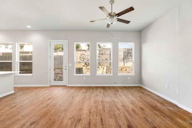 unfurnished room featuring light hardwood / wood-style floors, a wealth of natural light, and ceiling fan