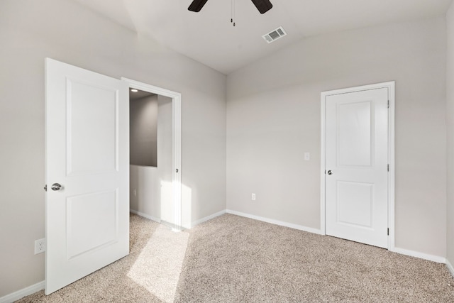 carpeted spare room featuring lofted ceiling and ceiling fan