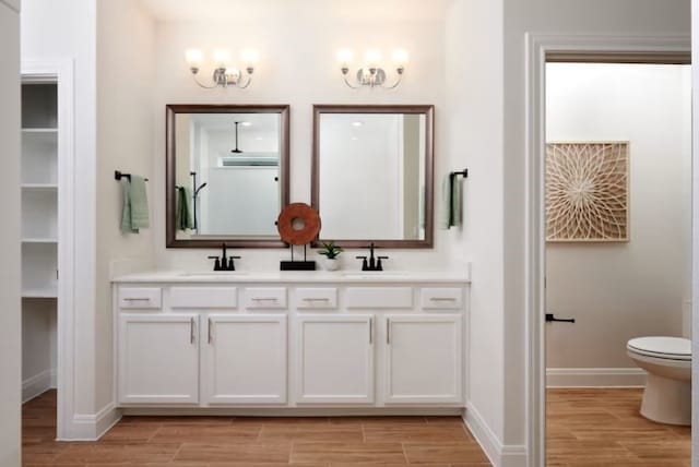 bathroom with wood-type flooring, vanity, and toilet