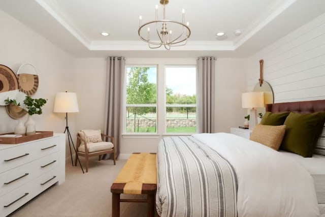 bedroom with a raised ceiling, light colored carpet, and a chandelier