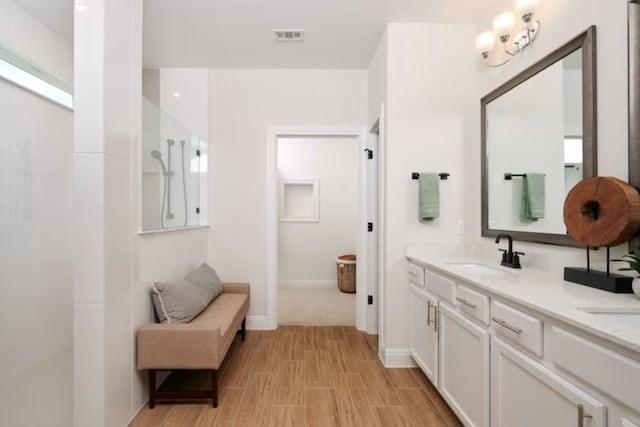 bathroom with walk in shower, vanity, and wood-type flooring