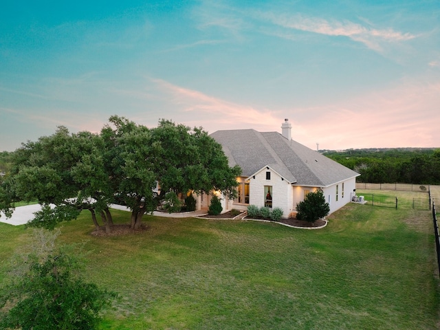 property exterior at dusk with a yard