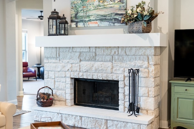 room details with a fireplace, wood-type flooring, and ceiling fan