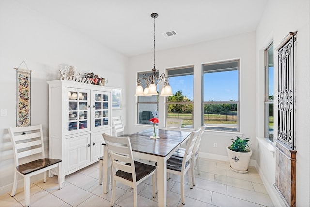 dining room with light tile patterned floors and a notable chandelier