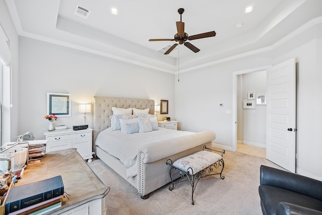 bedroom with a tray ceiling, ceiling fan, and light carpet