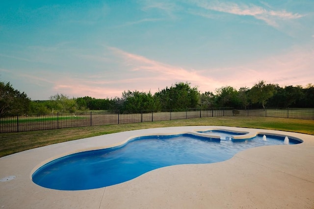 pool at dusk featuring a yard and a patio