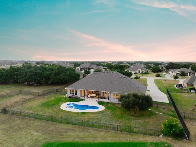 pool at dusk with a patio area and a yard