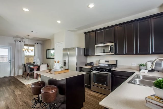 kitchen featuring a center island, stainless steel appliances, sink, dark hardwood / wood-style flooring, and pendant lighting