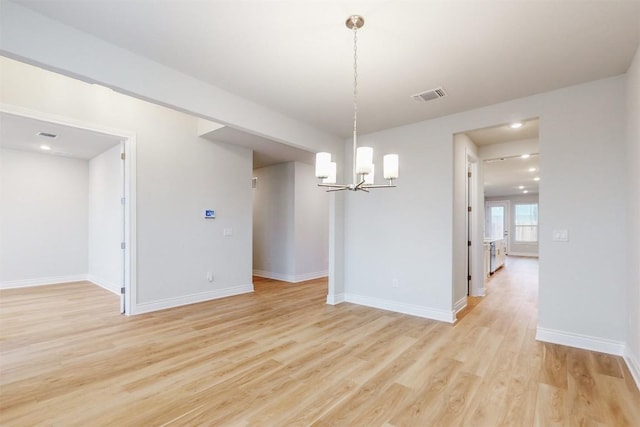 unfurnished dining area with a notable chandelier and light hardwood / wood-style floors