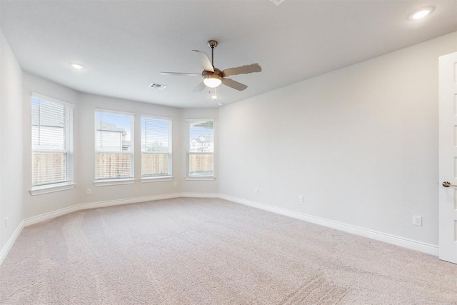 unfurnished room with light colored carpet and ceiling fan