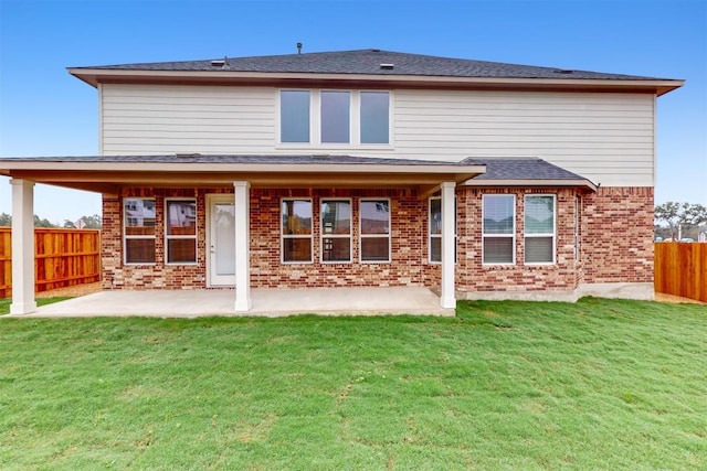 rear view of property featuring a patio area and a lawn