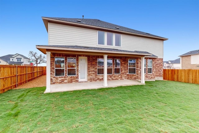 back of property with a lawn and a patio area