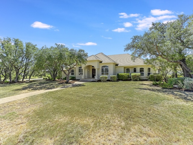 26801 Founders Pl, Spicewood, TX 78669 - view of front facade with a front yard and stucco siding