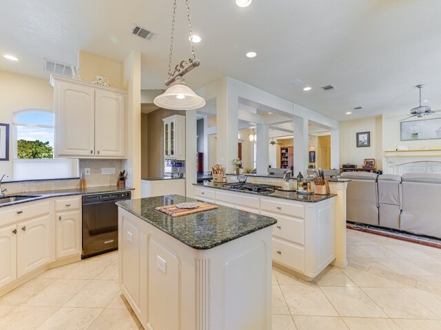 kitchen featuring a kitchen island, stainless steel gas cooktop, black dishwasher, and decorative light fixtures