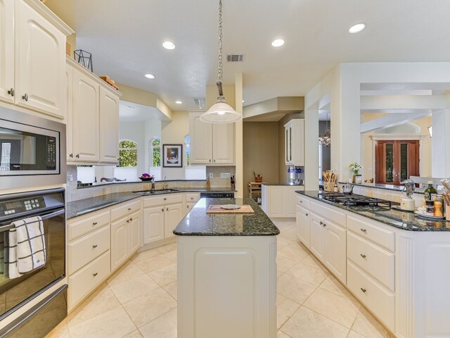 kitchen with decorative light fixtures, sink, kitchen peninsula, black appliances, and light tile patterned floors