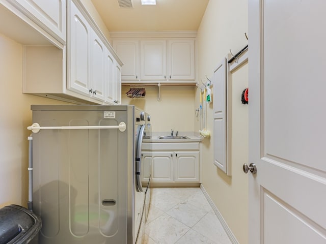 washroom with light tile patterned floors, sink, washing machine and clothes dryer, cabinets, and a barn door