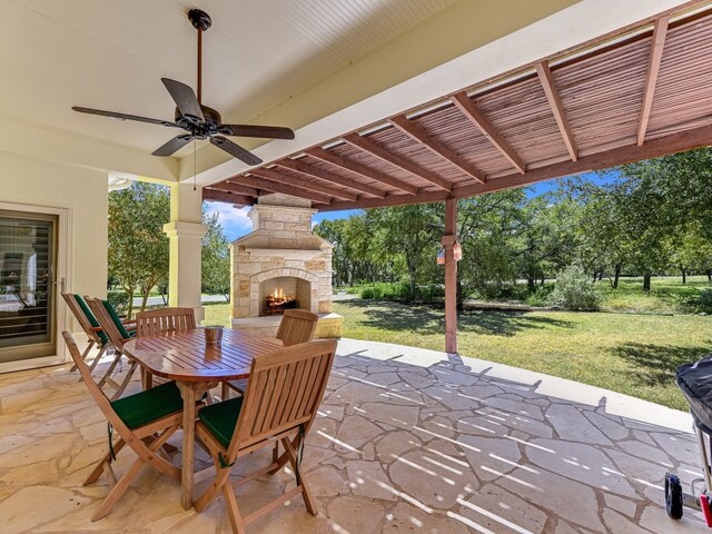 view of patio / terrace with ceiling fan and an outdoor stone fireplace