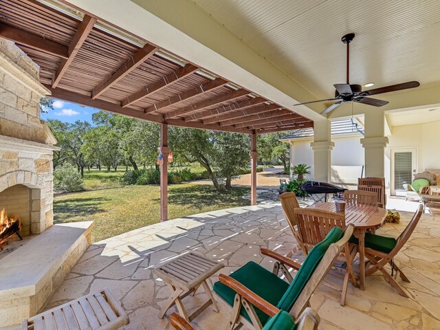 view of patio / terrace with an outdoor stone fireplace, a pergola, and ceiling fan