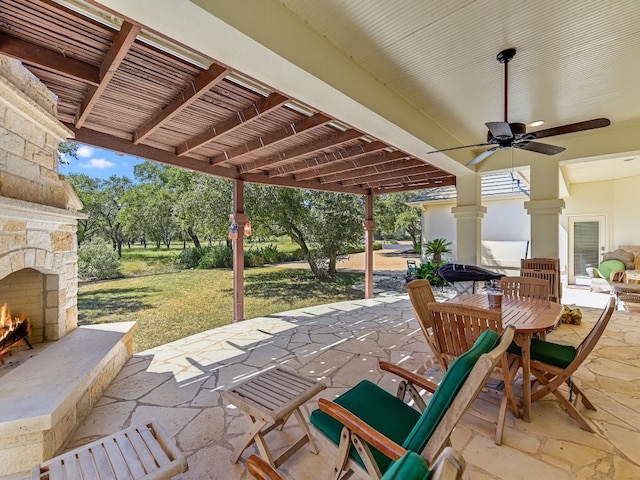 26801 Founders Pl, Spicewood, TX 78669 - view of patio with an outdoor stone fireplace, ceiling fan, and outdoor dining area