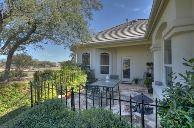 view of exterior entry with a patio