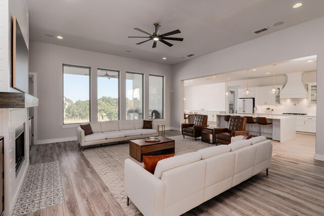 501 Francis Ct, Liberty Hill, TX 78642 - living area with a ceiling fan, a fireplace, baseboards, light wood-style floors, and recessed lighting