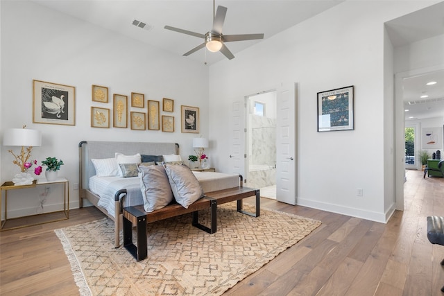 bedroom with wood-type flooring, connected bathroom, and ceiling fan