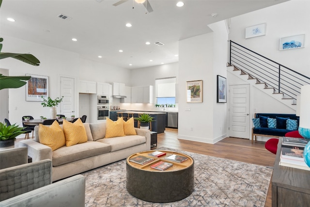 living room featuring ceiling fan and light hardwood / wood-style flooring