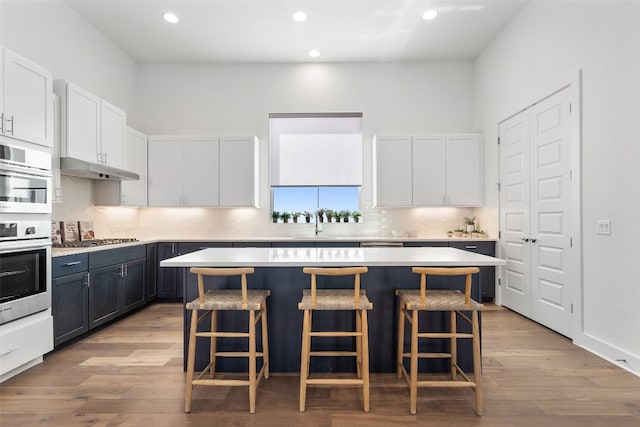 kitchen featuring a kitchen island, white cabinets, and a breakfast bar