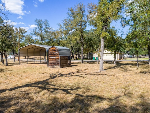 view of yard with a carport and an outdoor structure