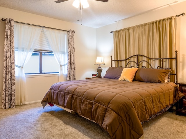 carpeted bedroom featuring a textured ceiling and ceiling fan