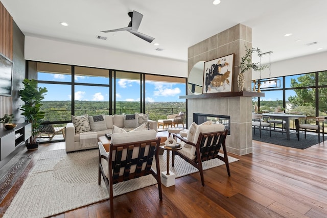 living room with a fireplace, wood-type flooring, and plenty of natural light