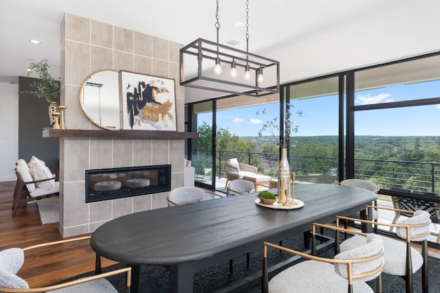 dining area featuring hardwood / wood-style floors and a tile fireplace